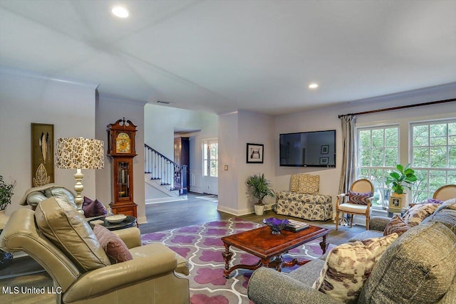 living room featuring dark wood-type flooring, ornamental molding, and a wealth of natural light