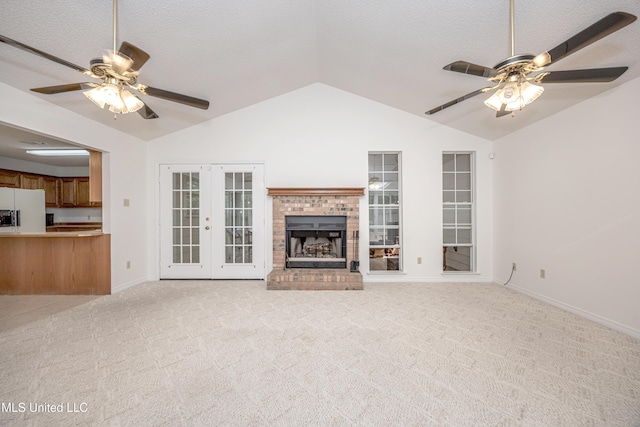 108 Water Oaks Cv, Ocean Springs, MS 39564 - unfurnished living room with a ceiling fan, lofted ceiling, french doors, light carpet, and a brick fireplace