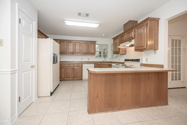 108 Water Oaks Cv, Ocean Springs, MS 39564 - kitchen featuring white appliances, under cabinet range hood, a peninsula, a sink, and light countertops