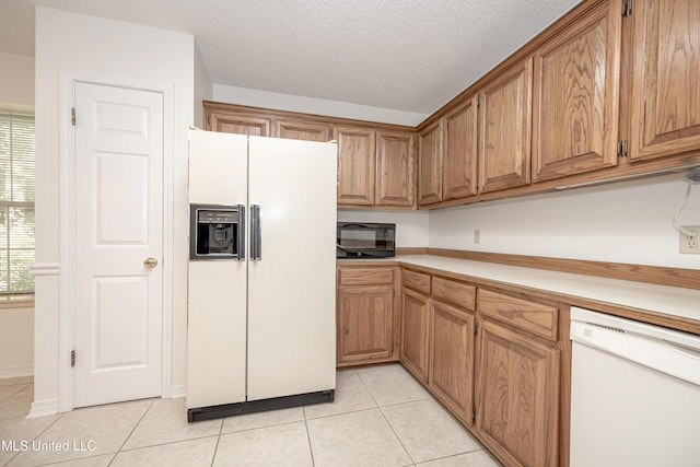 108 Water Oaks Cv, Ocean Springs, MS 39564 - kitchen with white appliances, light tile patterned floors, light countertops, brown cabinets, and a textured ceiling