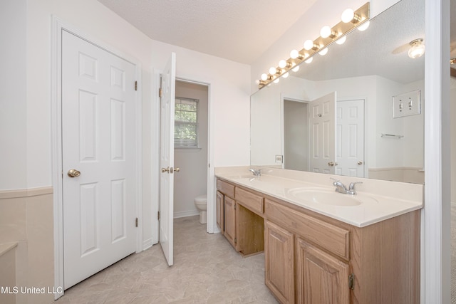 108 Water Oaks Cv, Ocean Springs, MS 39564 - full bathroom with double vanity, a textured ceiling, and toilet