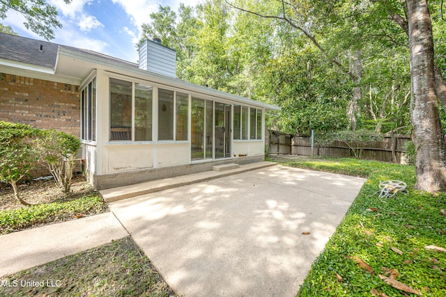 108 Water Oaks Cv, Ocean Springs, MS 39564 - rear view of property featuring a sunroom, brick siding, a chimney, and a patio area