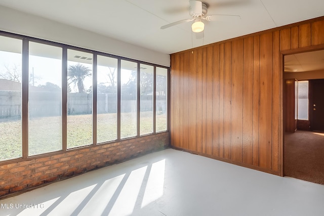 unfurnished sunroom featuring a water view and ceiling fan