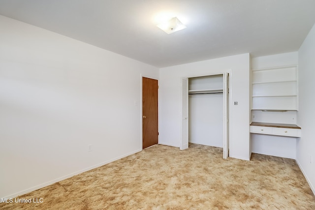 unfurnished bedroom with light carpet and a closet