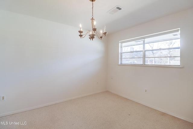 empty room featuring carpet flooring and a notable chandelier