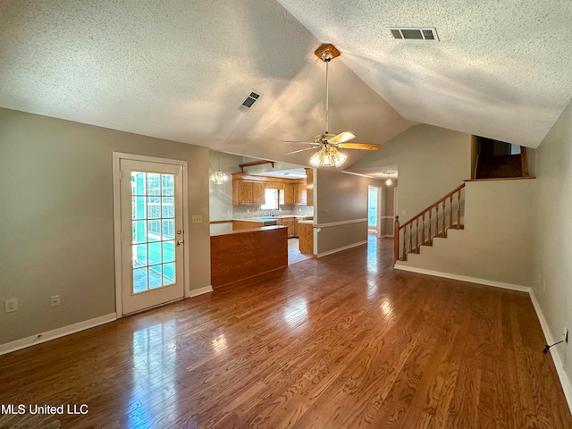 unfurnished living room featuring a textured ceiling, ceiling fan, and dark hardwood / wood-style flooring