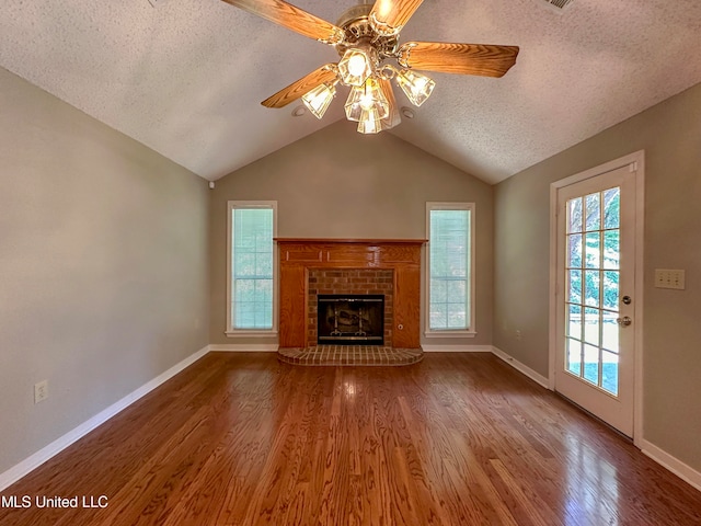 unfurnished living room featuring a wealth of natural light, hardwood / wood-style floors, vaulted ceiling, and ceiling fan