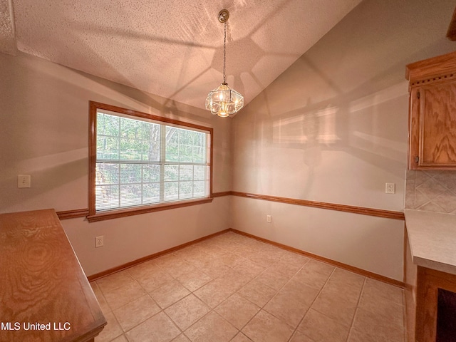 unfurnished dining area with vaulted ceiling, a notable chandelier, and a textured ceiling