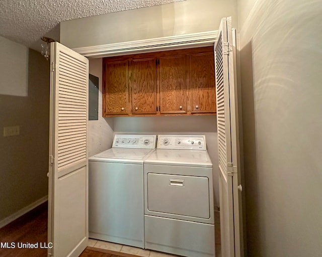 laundry area with cabinets, a textured ceiling, and separate washer and dryer