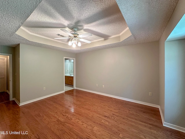 unfurnished room with hardwood / wood-style floors, a tray ceiling, a textured ceiling, and ceiling fan