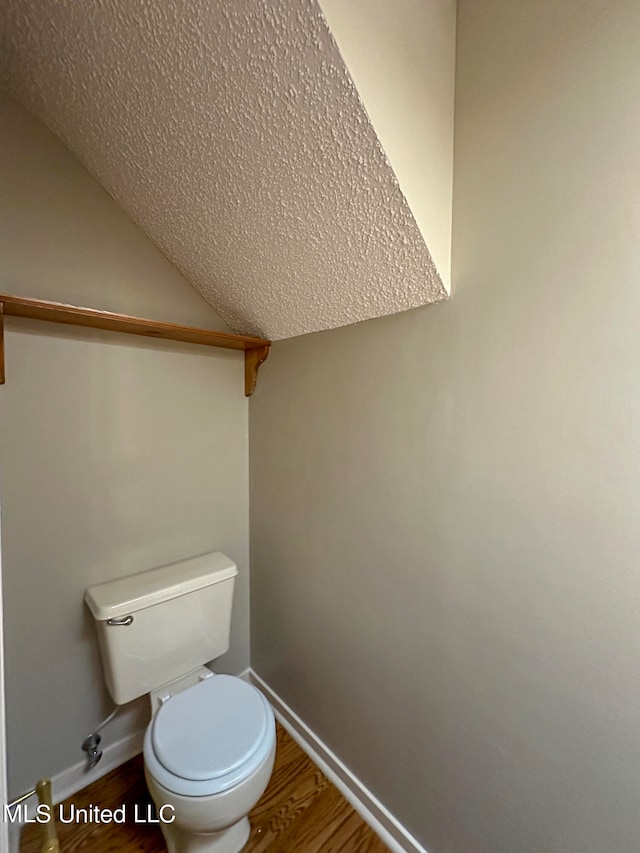 bathroom with toilet and hardwood / wood-style floors