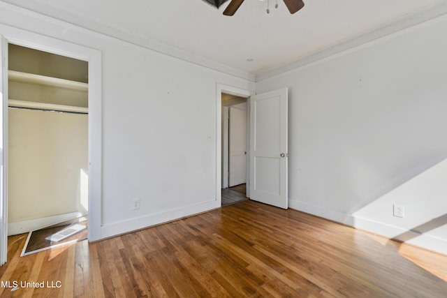 unfurnished bedroom featuring ornamental molding, a ceiling fan, baseboards, and wood-type flooring