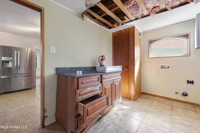 kitchen with visible vents, baseboards, stainless steel fridge, and brown cabinets