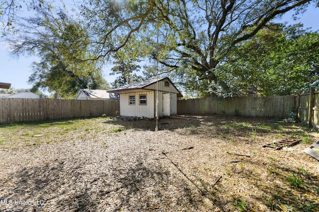 view of yard with an outbuilding, a fenced backyard, and a shed