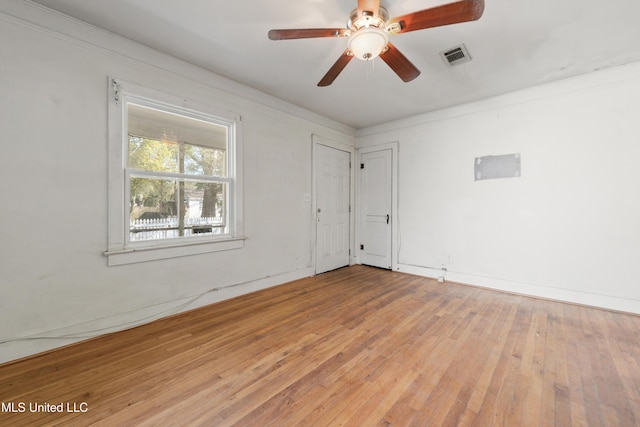 empty room featuring visible vents, wood-type flooring, baseboards, and ceiling fan