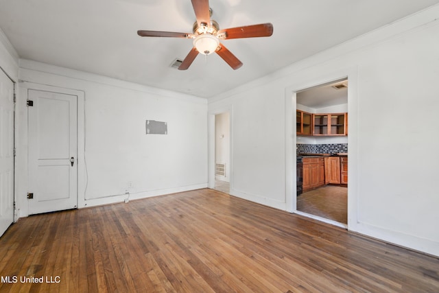 unfurnished bedroom with dark wood finished floors, visible vents, baseboards, and ornamental molding