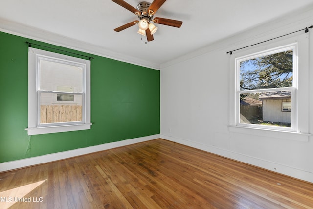 spare room featuring ceiling fan, hardwood / wood-style flooring, baseboards, and ornamental molding