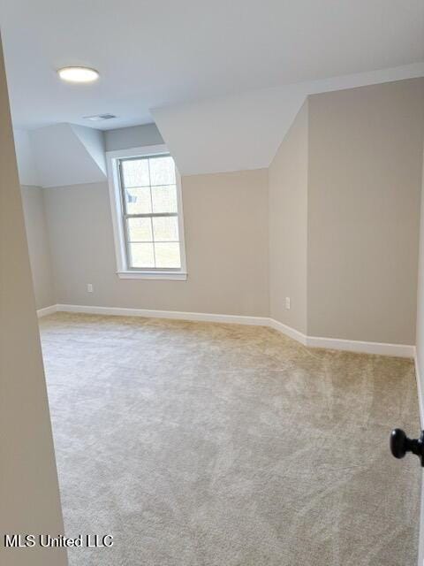 bonus room featuring lofted ceiling and light colored carpet