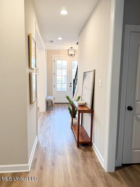 corridor featuring wood finished floors and baseboards