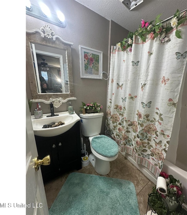 bathroom featuring tile patterned flooring, toilet, vanity, shower / tub combo, and a textured ceiling