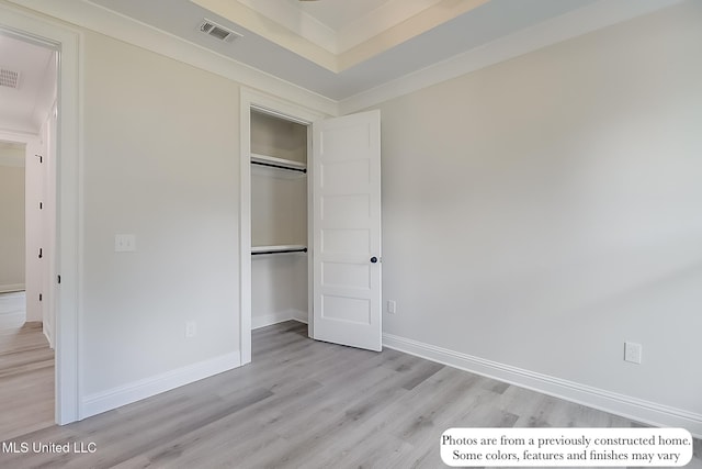unfurnished bedroom featuring light wood-style floors, baseboards, a closet, and visible vents