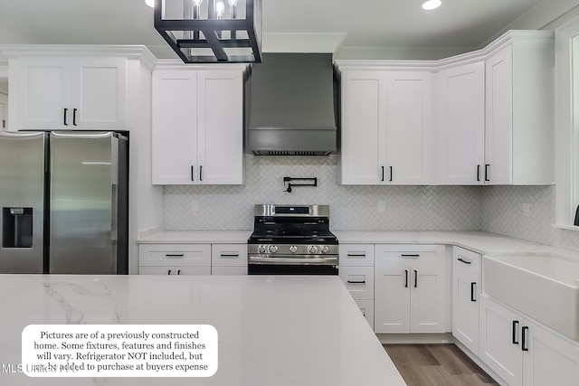 kitchen with appliances with stainless steel finishes, white cabinetry, decorative backsplash, wood finished floors, and custom exhaust hood