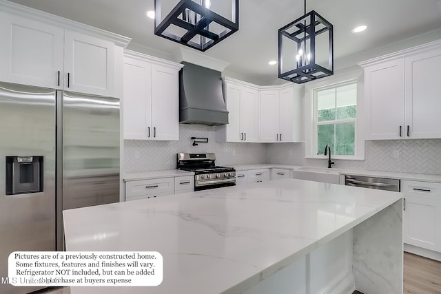 kitchen with custom range hood, a sink, white cabinetry, and stainless steel appliances