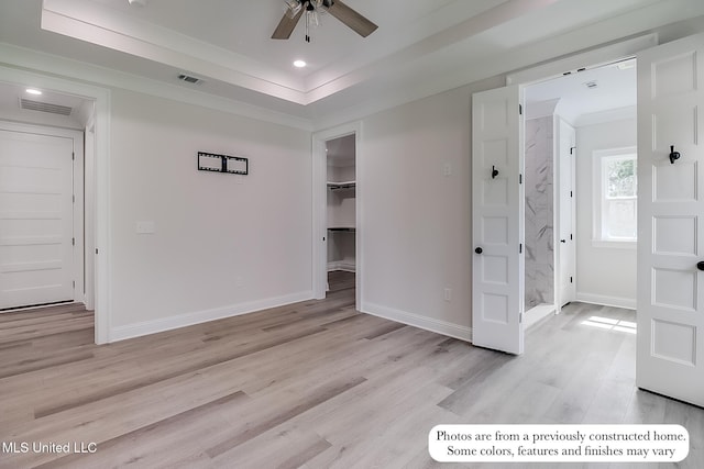 unfurnished bedroom featuring visible vents, light wood-style floors, crown molding, and baseboards