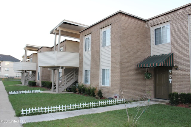 contemporary house featuring a balcony and a front yard