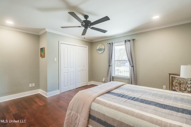 bedroom featuring dark wood-style flooring, a closet, crown molding, and baseboards