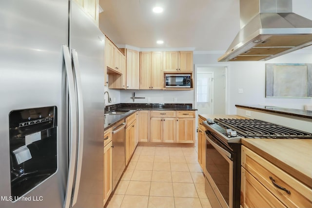 kitchen with stainless steel appliances, light tile patterned flooring, light brown cabinets, a sink, and exhaust hood