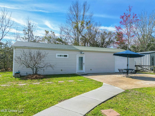 view of front of home with a patio and a front lawn