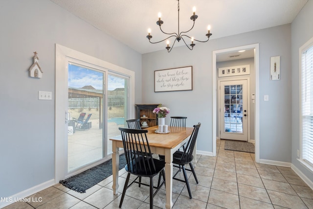 dining space with a notable chandelier and light tile patterned flooring