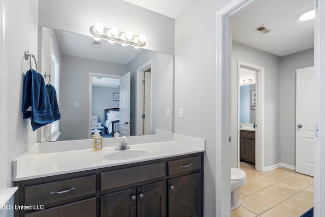 bathroom with vanity, toilet, and tile patterned flooring