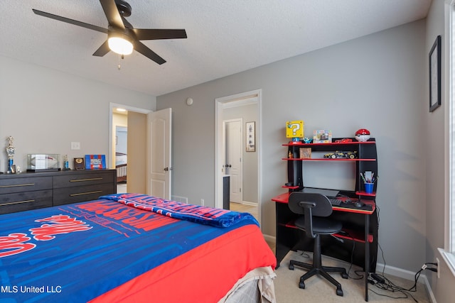 carpeted bedroom with ceiling fan and a textured ceiling