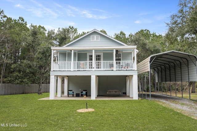 view of front of home with driveway, covered porch, fence, a carport, and a front yard