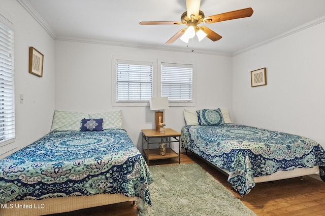 bedroom with a ceiling fan, ornamental molding, and wood finished floors