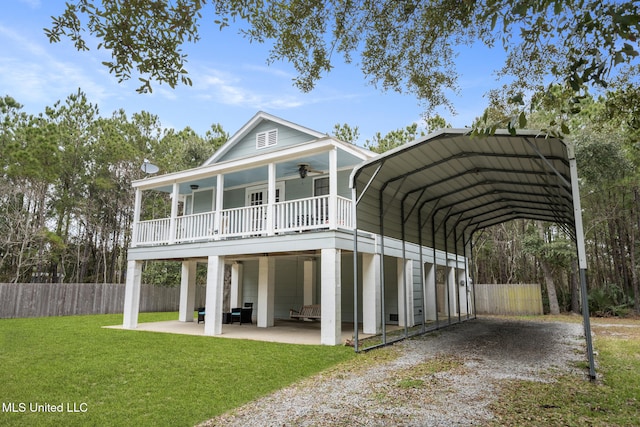 back of property with driveway, a ceiling fan, fence, a yard, and a porch