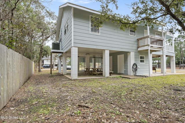 rear view of house featuring a patio, a balcony, and fence