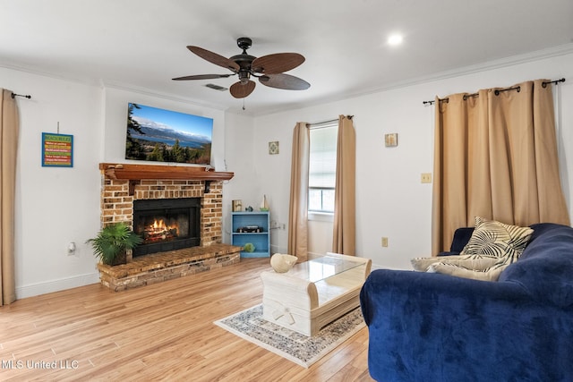 living room with a fireplace, visible vents, ornamental molding, wood finished floors, and baseboards