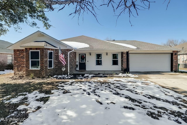 single story home with a garage, a shingled roof, concrete driveway, and brick siding