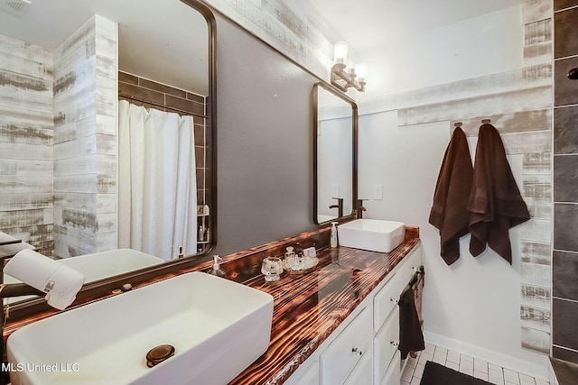 full bath with double vanity, curtained shower, visible vents, and a sink