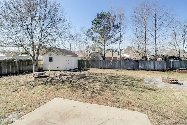 view of yard with an outdoor fire pit, a patio, a fenced backyard, and an outdoor structure