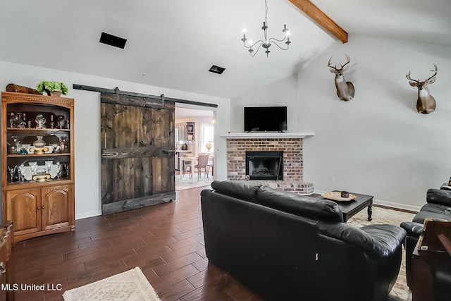 living area with a barn door, lofted ceiling with beams, dark wood-style flooring, a fireplace, and a notable chandelier