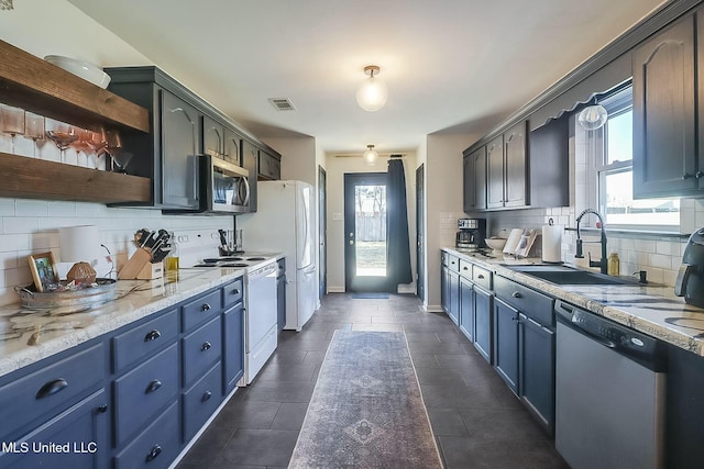 kitchen with open shelves, stainless steel appliances, visible vents, a sink, and baseboards