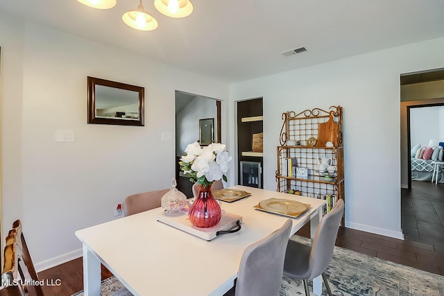 dining area featuring baseboards, visible vents, and dark wood-style flooring