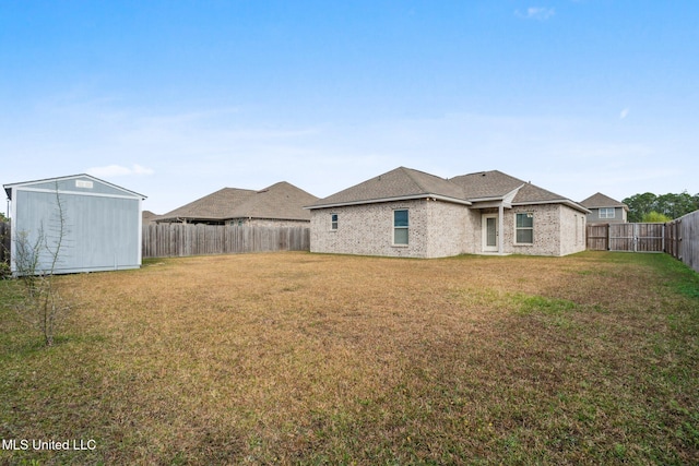 rear view of property with a lawn and a shed