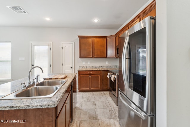 kitchen featuring a center island with sink, sink, and appliances with stainless steel finishes