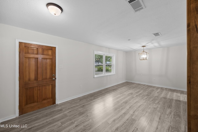 2389 Napoleon Ave, Pearl, MS 39208 - unfurnished room with a chandelier, light wood-style floors, visible vents, and baseboards