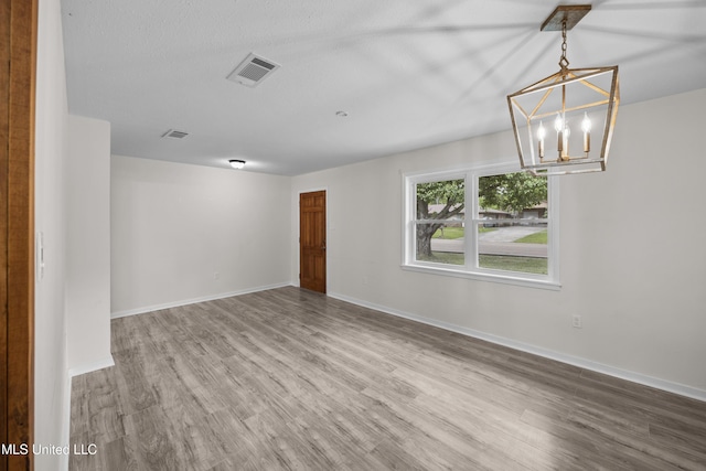 2389 Napoleon Ave, Pearl, MS 39208 - unfurnished room with baseboards, wood finished floors, visible vents, and an inviting chandelier